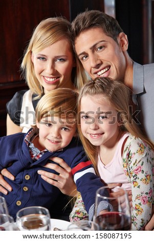 Happy family with two children sitting at the dinner table