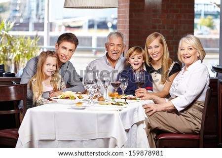 Happy family with children and seniors eating out in a restaurant