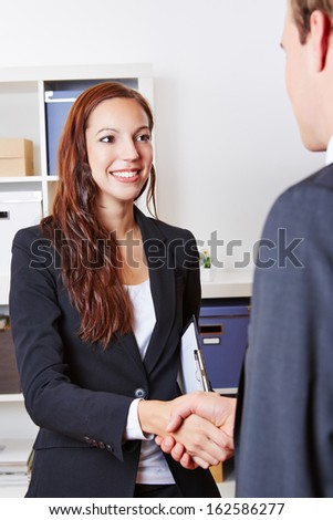 Welcome handshake with two businesspeople in their office