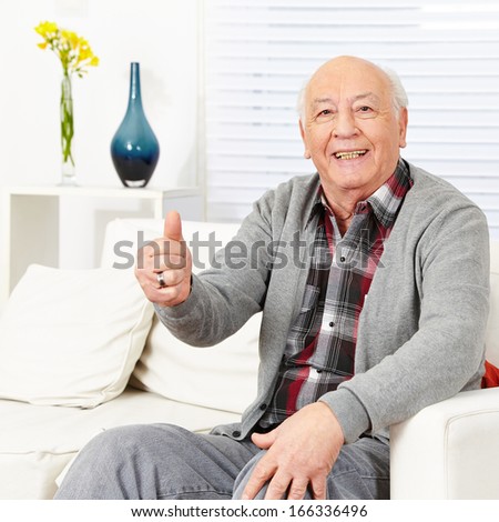 Old happy man holding thumbs up in a retirement home