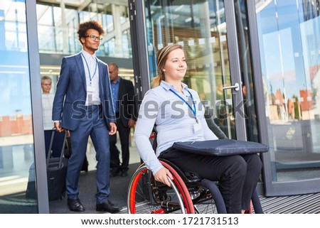 Smiling businesswoman in a wheelchair leaves the barrier-free business company Stock foto © 