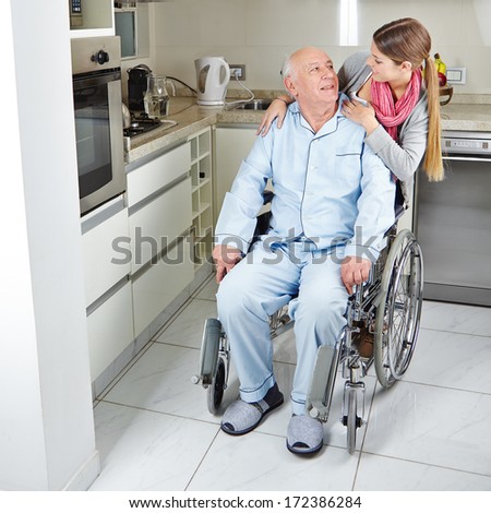 Family with senior man in wheelchair at home in the kitchen