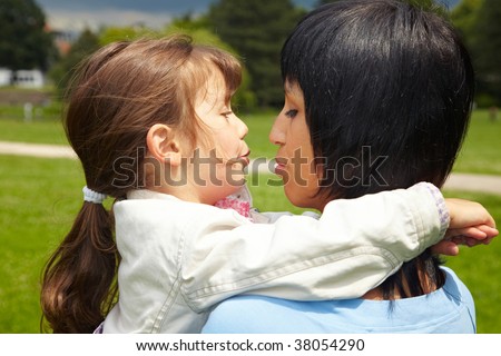 Mother and daughter talking in a park