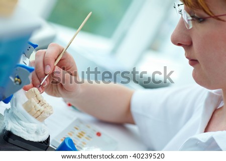 Dental technician working on ceramic inlays in a lab