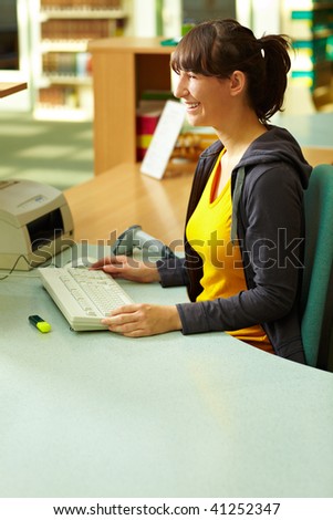 Library staff sitting at checkout counter in library