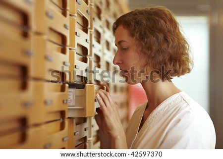 Female pharmacist at medicine cabinet in pharmacy