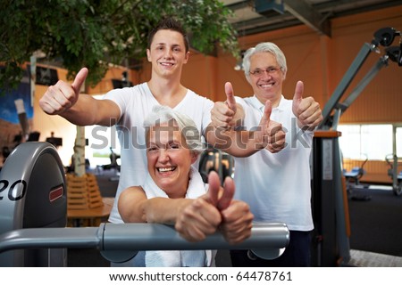 Successful fitness team in a gym holding thumbs up