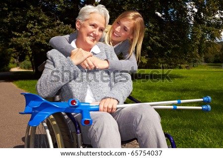 Happy grandmother in wheelchair with her grandchild in a park