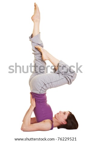 Young woman doing a shoulder stand as yoga exercise