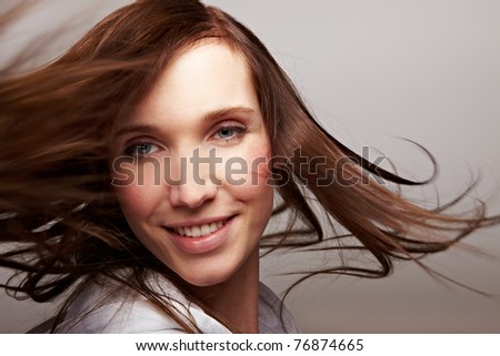 Happy dancing woman smiling with long brown hair