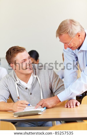 Senior lecturer helping a student in university class