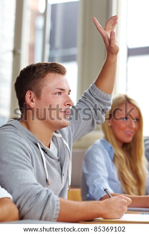 Student raising his hand in university class