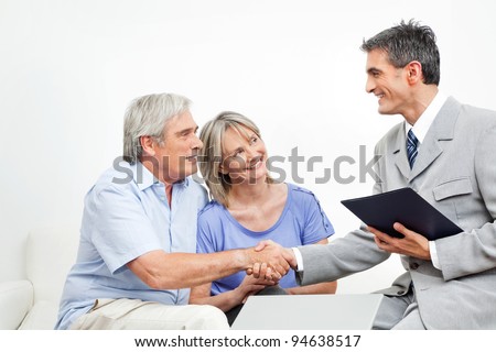 Handshake between senior couple and financial consultant