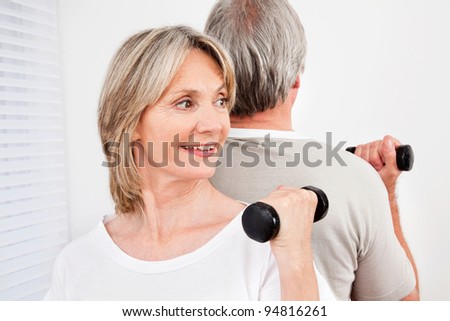 Senior couple back to back in fitness class in gym