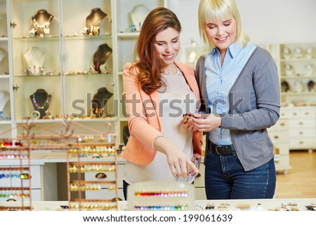 Personal Shopper advising woman in jewelry store while buying a bracelet