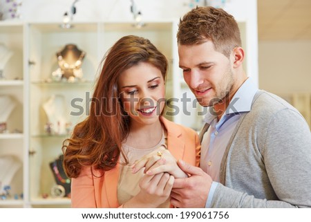 Happy couple trying on rings at a jewelry store