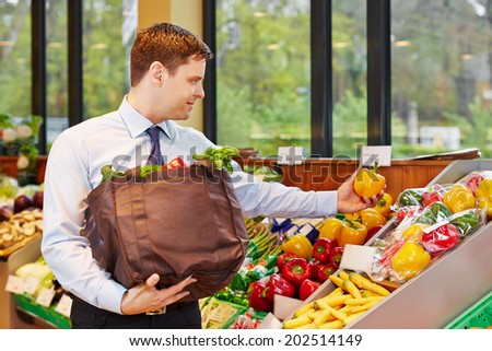Smiling businessman buying fresh vegetables in an organic food store