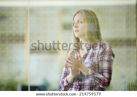Young woman clapping hands for applause in the office behind glass