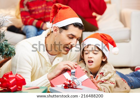 Father and son opening gifts together at christmas eve