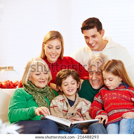 Happy three generation family reading story book at christmas