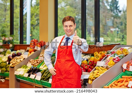 Smiling store manager in a supermarket holding his thumbs up