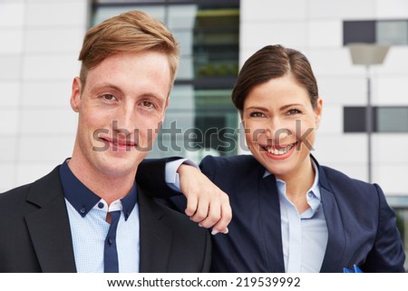Portrait of two happy business consultant people in front of office
