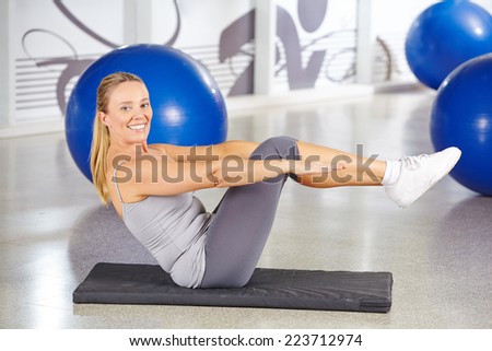 Sportive elderly woman doing gymnastics in a gym