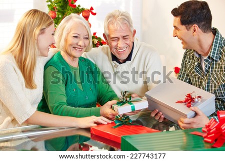 Happy senior citizens celebrating christmas with their children and gifts