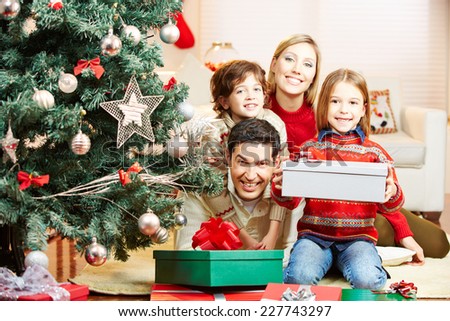 Happy family at home with christmas tree and gifts and children