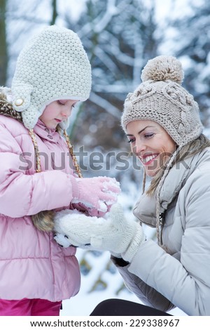 Mother and child playing together in winter snow