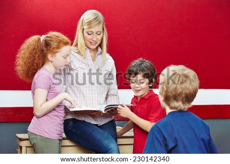 Students and teacher reading book in elementary school