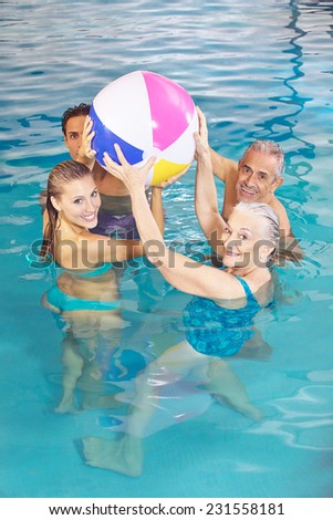 Happy family with senior couple playing with water ball in swimming pool