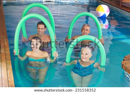 Smiling group doing aqua fitness class together in a swimming pool