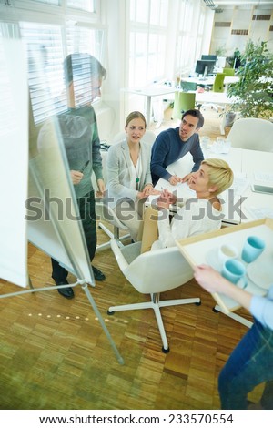 Team meeting in conference room of office with man at whiteboard