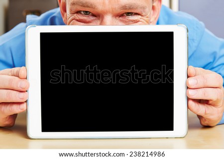 Business man looking behind tablet computer in office