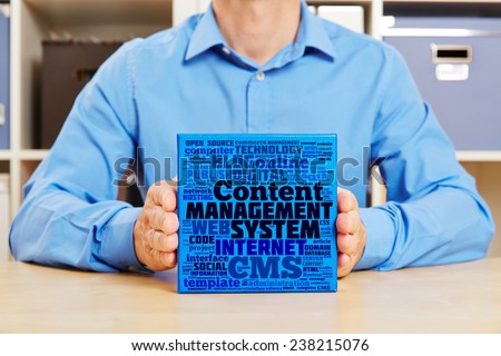 Hands holding Content Management System concept on a blue box