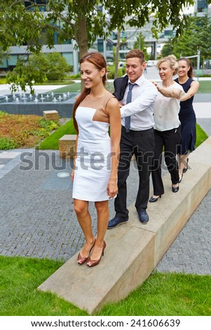 A happy group of business people walking behind each other outdoors