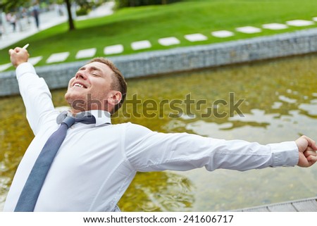 Relaxed business man stretching his arms outdoors on a chair