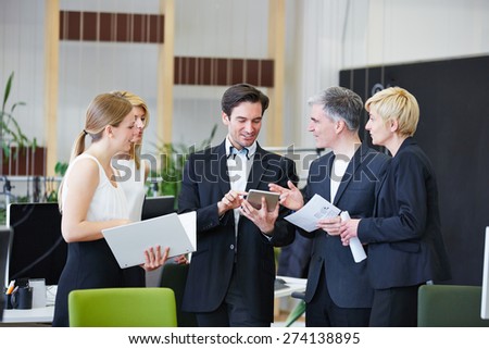 Business men and women in office working with tablet PC