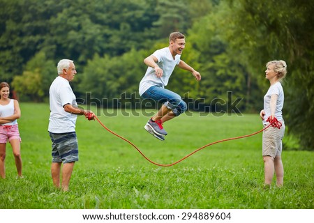 Man rope skipping with jumping rope with his family in nature
