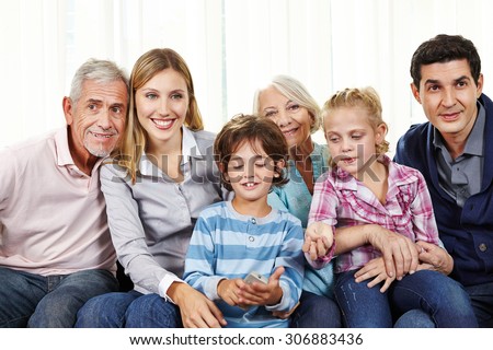 Family watching Smart TV with remote control in living room