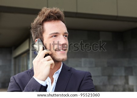 Young business man making cell phone call in urban city