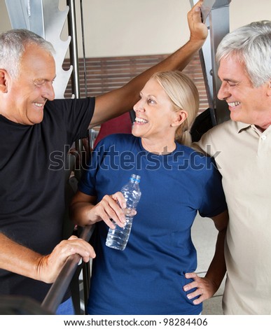 Three senior people talking in gym while having a break