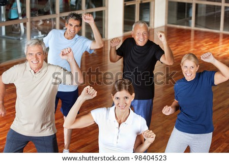 Happy senior group moving and dancing in fitness center