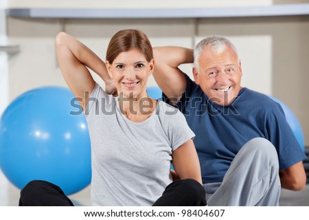 Elderly happy sport group doing back exercises in gym
