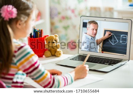 Middle-aged distance teacher having video conference call with pupil using webcam. Online education and e-learning concept. Home quarantine distance learning and working from home.