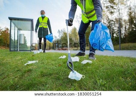 Similar – Image, Stock Photo Coronavirus garbage. Volunteers collecting used disposable medical masks and gloves near the bus stop and along the highway. The problem of environmental pollution during a pandemic COVID-19