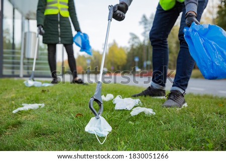 Similar – Image, Stock Photo Coronavirus garbage. Volunteers collecting used disposable medical masks and gloves near the bus stop and along the highway. The problem of environmental pollution during a pandemic COVID-19