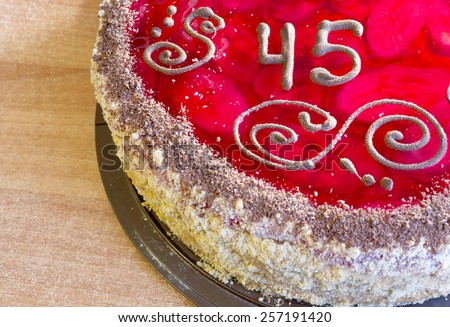 Delicious cake with number forty-five on a wooden background
