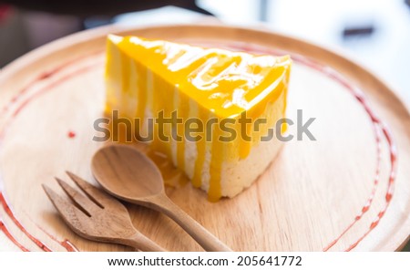 Mango mousse cake on wood plate